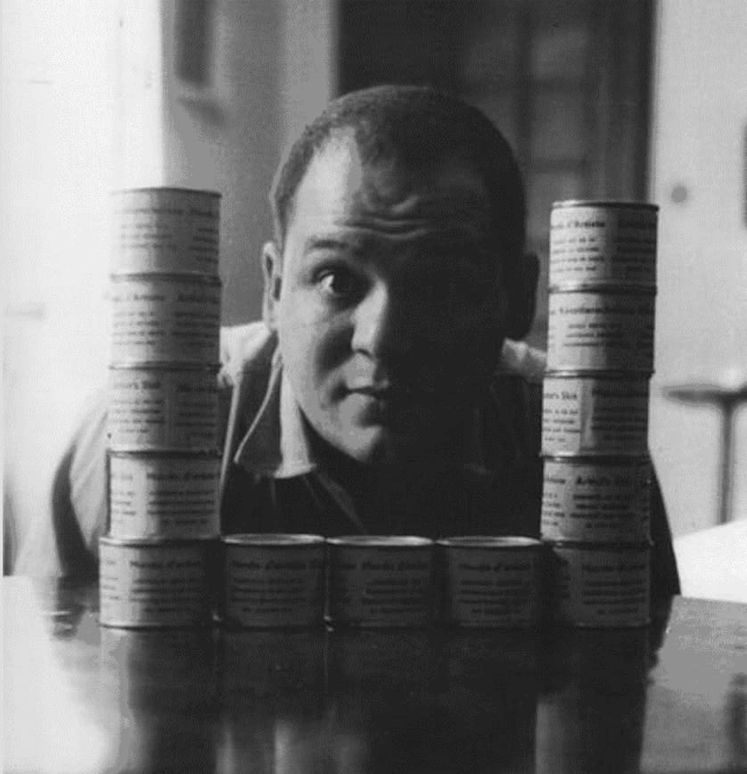 Piero Manzoni posing with his artwork