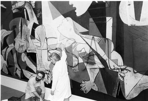 Museum of Modern Art Employees clen spray paint off of Guernica by Picasso after Tony Shafrazy vandalised it, February 1974. Vandalism