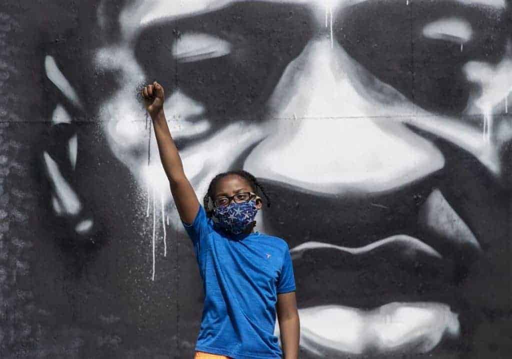 A child stands in front of a mural honouring George Floyd in Minneapolis in 2020. Photo: Victor J. Blue for the New York Times.