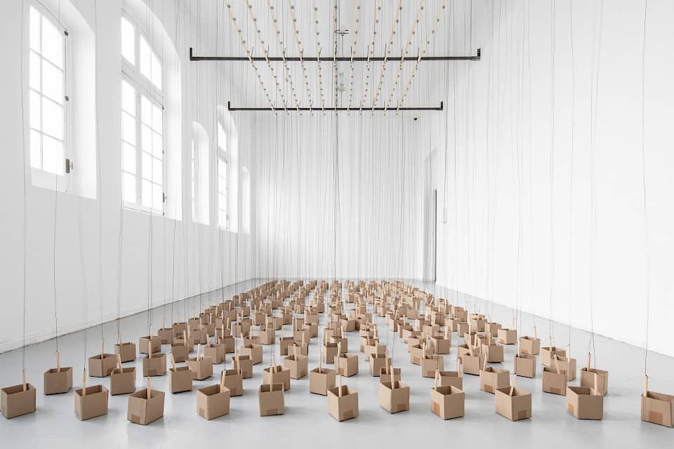 https://magazine.artland.com/wp-content/uploads/2021/07/Zimoun-297-prepared-dc-motors-1247m-rope-wooden-sticks-19cm-cardboard-boxes-10x10x10cm-2019.-Installation-view-at-the-Museum-of-Contemporary-Art-MAC-Santiago-de-Chile-2019.jpg