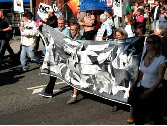 Protesters with a banner depicting Guernica