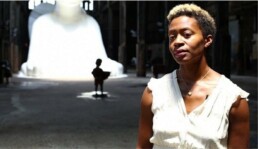 Kara Walker standing in front of her installation at the Domino Sugar Factory in Brooklyn, NY.