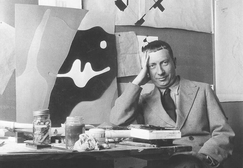 Portrait of Dadaist artist Jean Arp sitting in his office